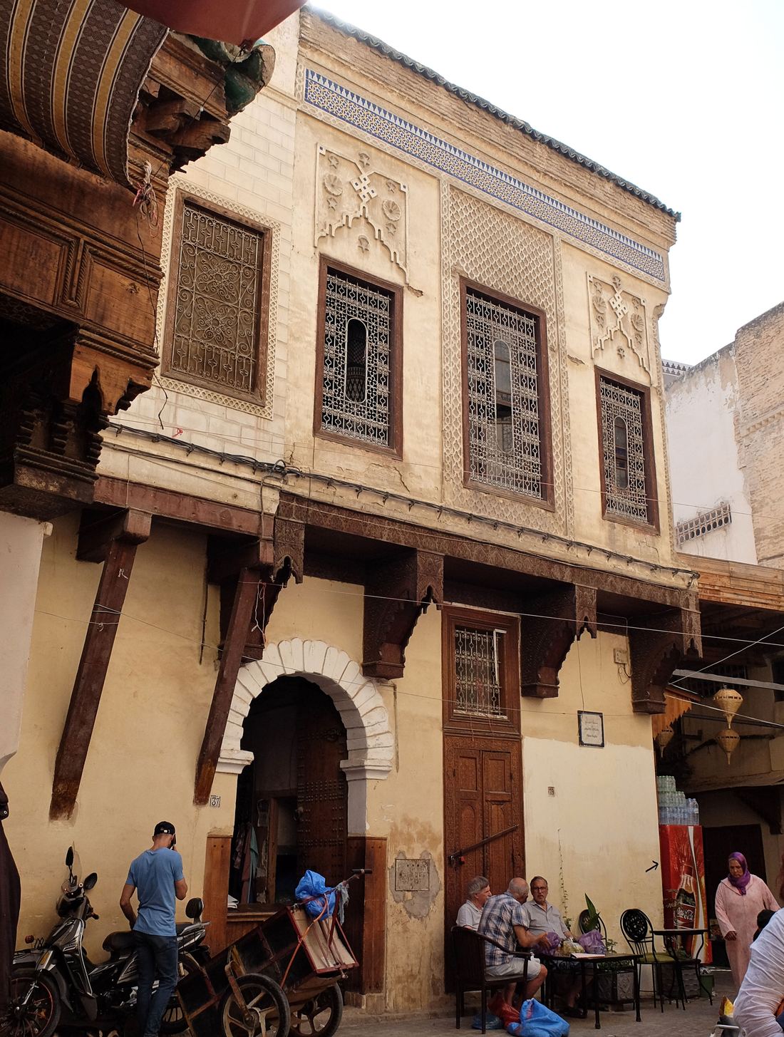 A narrow, busy lane in the medina of Fes lined with shops